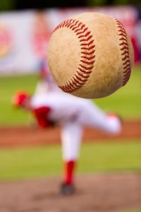 A baseball player pitching (focus on the ball)