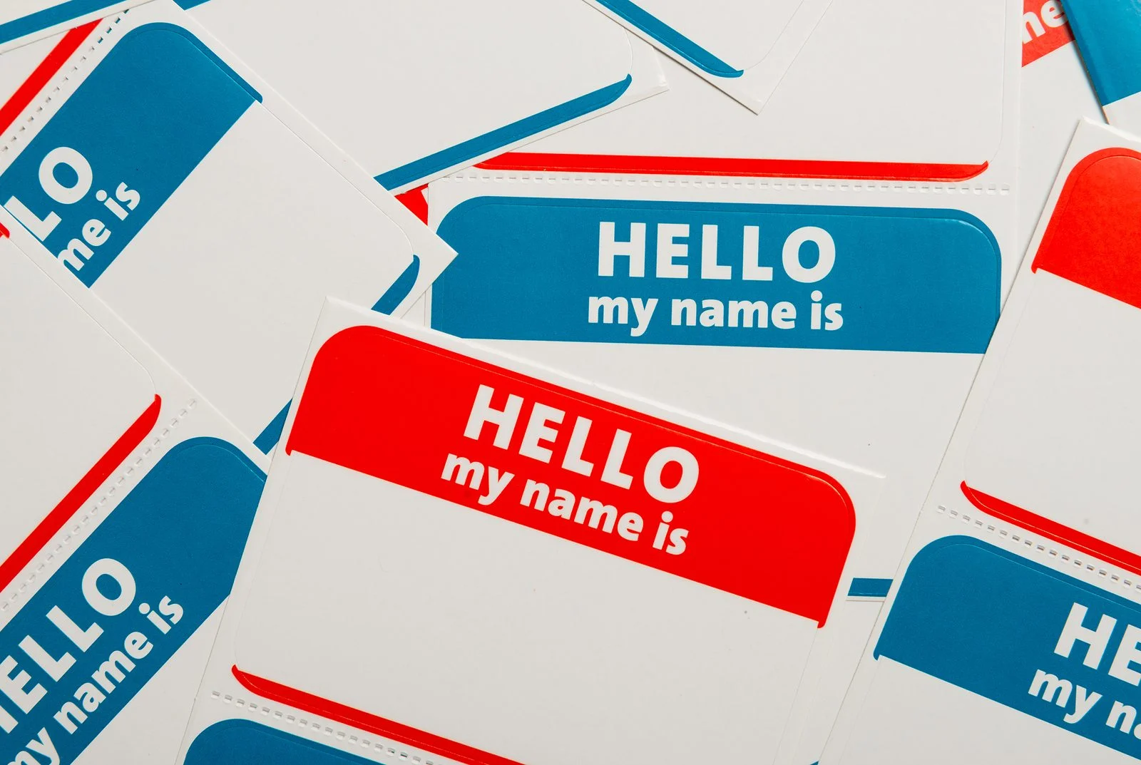 A stack of blue and red “Hello, my name is” name tags or badges
