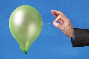 Needle about to pop a green balloon
