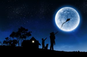 Silhouettes of happy family at night under full moon